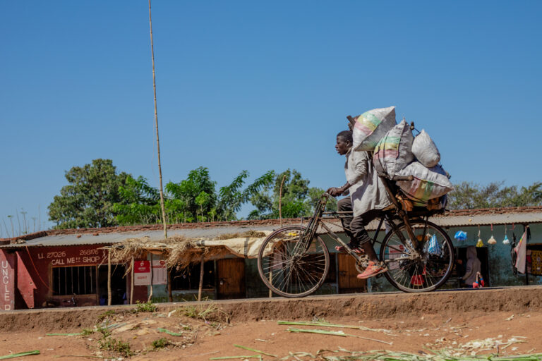 Man carrying charcoal on a bicycle.